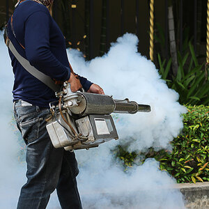 A person spraying larvicide to prevent mosquitos and the spread of malaria. A person spraying larvicide to prevent mosquitos and the spread of malaria.