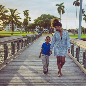 A mother and son walking with palm trees behind them. A mother and son walking with palm trees behind them.