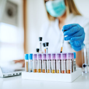 A scientist using blood vials for research.