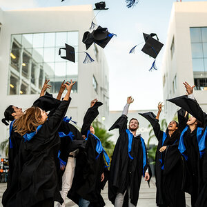 College grads celebrating by tossing their caps in the air. College grads celebrating by tossing their caps in the air.