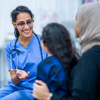 A female doctor smiles at her young patient during a check up. A female doctor smiles at her young patient during a check up.