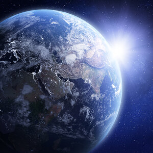 An image of Earth from space with the sun rising over Asia.