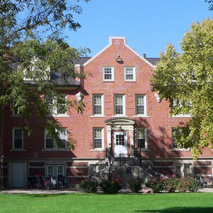 A red brick and stone college building surrounded by trees and grass—Hastings College. A red brick and stone college building surrounded by trees and grass—Hastings College.