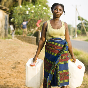A woman carrying two jugs of water. A woman carrying two jugs of water.