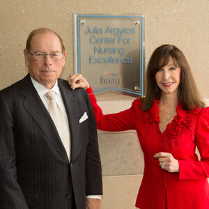 A couple stand in front of a sign at a hospital – George and Julia Argyros. A couple stand in front of a sign at a hospital – George and Julia Argyros.