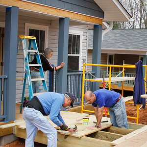 Volunteers building a handicapped accessible ramp for a house.