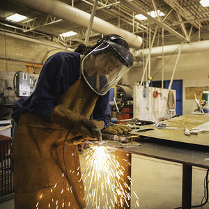 A woman welding in a shop. A woman welding in a shop.
