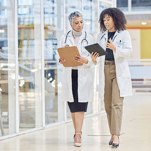 A researcher and her mentor walking in a hospital. A researcher and her mentor walking in a hospital.