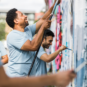 Volunteers painting a mural on a wall in a public space. Volunteers painting a mural on a wall in a public space.