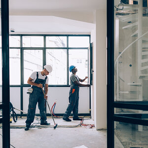 Two construction workers inside an apartment. Two construction workers inside an apartment.