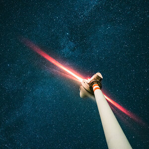 A wind turbine at night, looking up at the stars