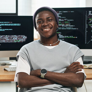 An African computer programmer crosses his arms and smiles for the camera. An African computer programmer crosses his arms and smiles for the camera.