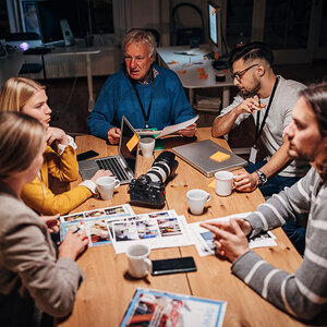 A newsroom with journalists having a meeting. A newsroom with journalists having a meeting.
