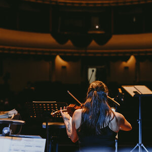 A violinist performing on stage. A violinist performing on stage.