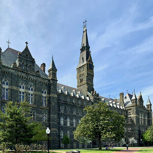 The gothic façade of a college building surrounded by grass and trees – Georgetown University.