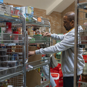 A person restocking a pantry.