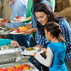 A young girl is served a meal at a community kitchen. A young girl is served a meal at a community kitchen.
