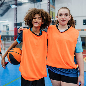 A boy and girl playing basketball pose for a photo. A boy and girl playing basketball pose for a photo.