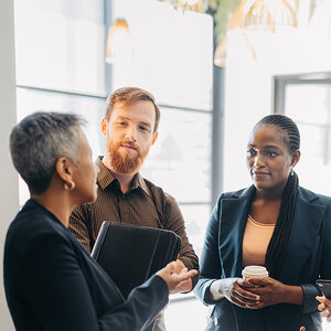 Three professionals gather for a serious conversation.