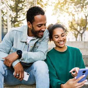 A young Latinx couple on the phone. A young Latinx couple on the phone.