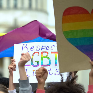 A rally with posters for LGBTQ rights.