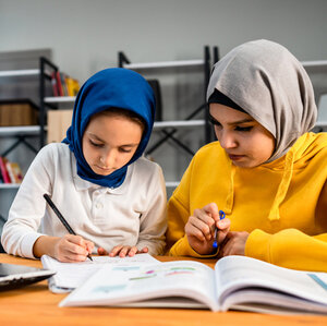 Muslim sisters doing homework. Credit Gettty Images/Phynart Studio.