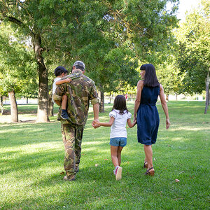 A military family walking in a park.