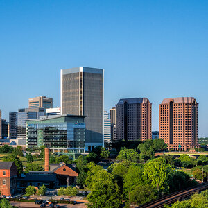 A city skyline with trees and older buildings in the foreground – Richmond, Virginia.