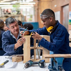 A teacher and student working on a wood project. A teacher and student working on a wood project.