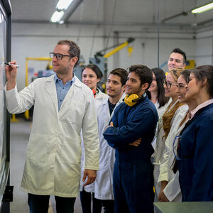 Engineering students with their teacher writing on the board. Engineering students with their teacher writing on the board.