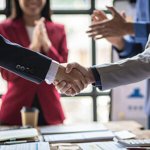 Two people shaking hands during a meeting. Two people shaking hands during a meeting.