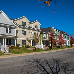 A row of houses with newly planted trees under a deep blue sky. A row of houses with newly planted trees under a deep blue sky.