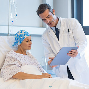 A cancer patient and a doctor reviewing charts. A cancer patient and a doctor reviewing charts.