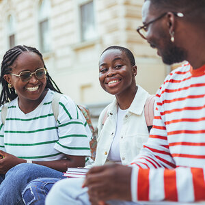 Teens sitting on step together.