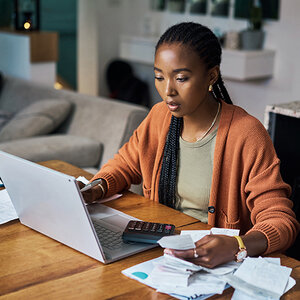 A South African woman sits at her laptop, working.