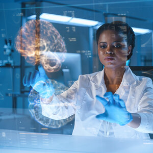 A doctor reviewing a brain scan on a transparent screen.