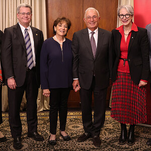 Four well-dressed people posing for a photo.