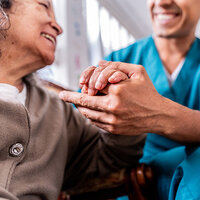 An elderly woman holding a nurse's hand. An elderly woman holding a nurse's hand.