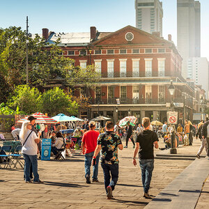 People walking in a public square surrounded by trees and old buildings – New Orleans. People walking in a public square surrounded by trees and old buildings – New Orleans.