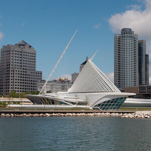 An architecturally striking museum on the shore of a lake with skyscrapers in the background—a photo of the Milwaukee Art Museum. An architecturally striking museum on the shore of a lake with skyscrapers in the background—a photo of the Milwaukee Art Museum.