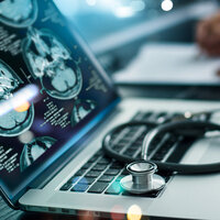 A scan of a brain resting on a laptop with a doctors stethoscope on top. A scan of a brain resting on a laptop with a doctors stethoscope on top.