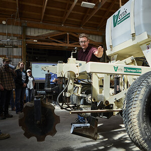 A Montana State University professor, standing beside a wheeled farm-related vehicle, instructs students in agricultural equipment. A Montana State University professor, standing beside a wheeled farm-related vehicle, instructs students in agricultural equipment.
