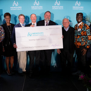 A group of people pose for a photo at a grant announcement event.
