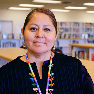 A Native American woman in a library.