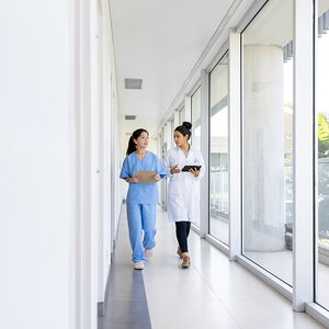 Two residents walk down a hospital cooridor.