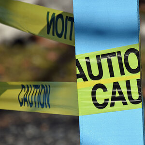 Yellow caution tape wrapped around a pole. Yellow caution tape wrapped around a pole.