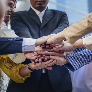 People placing their hands together in gesture of solidarity.