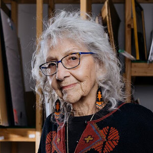 An older woman with silver-gray hair wearing glasses - a photo of Nora Chapa Mendoza.