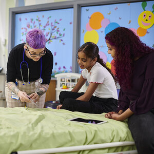 A doctor talking to a child in a hospital. A doctor talking to a child in a hospital.