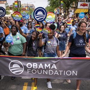 Members of the Obama Foundation marching with the foundation banner. Members of the Obama Foundation marching with the foundation banner.